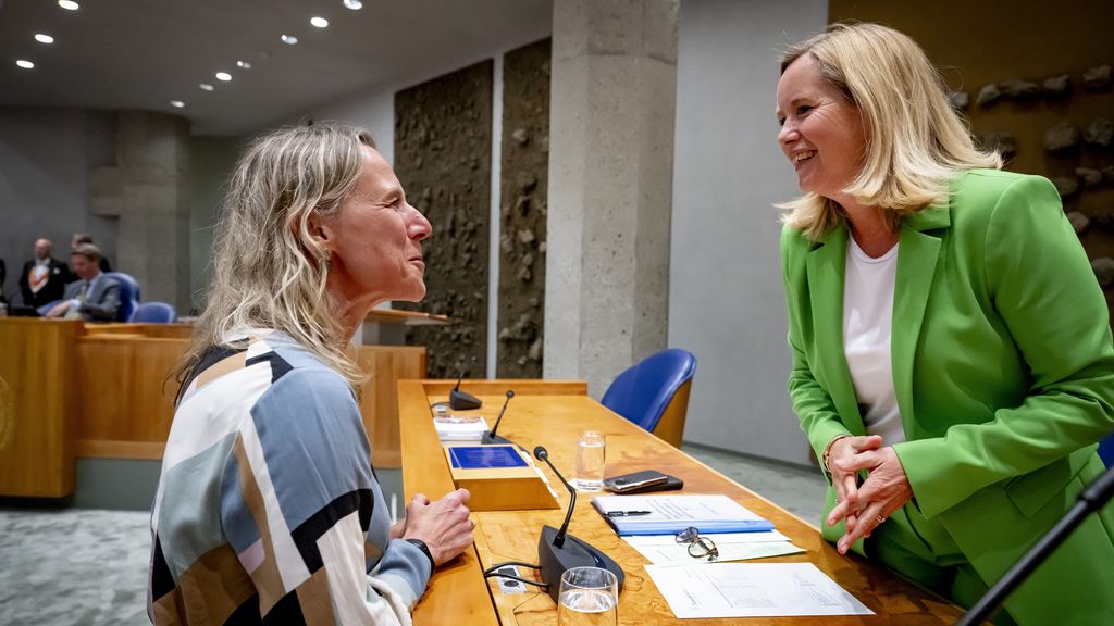 Twee vrouwen in gesprek in vergaderzaal.