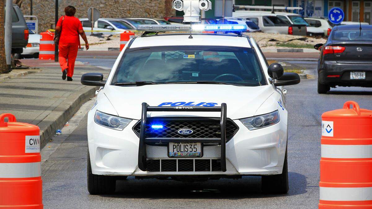 Politiewagen met blauwe lichten op straat.