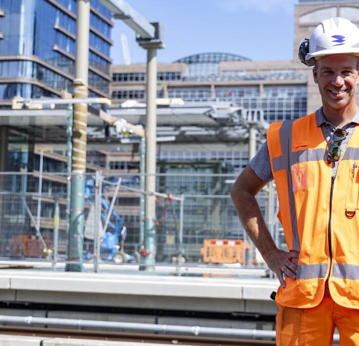 Bouwvakker bij stadsbouwplaats met helm en hesje