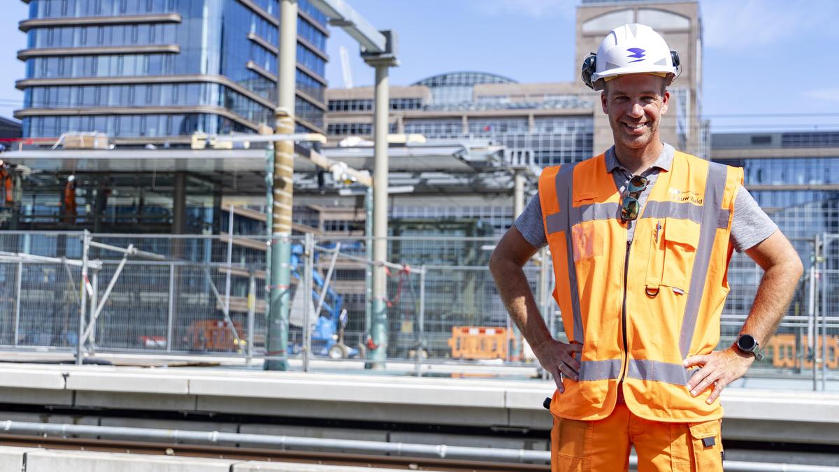 Bouwvakker bij stadsbouwplaats met helm en hesje